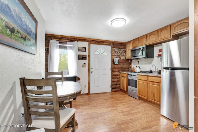704 S Freeman Way, Big Lake, AK 99623 - kitchen featuring stainless steel appliances, a textured ceiling, light wood finished floors, and a sink