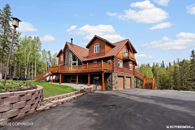 4601 E 104th Ave, Anchorage, AK 99507 - cabin with stairs, stone siding, asphalt driveway, an attached garage, and log exterior