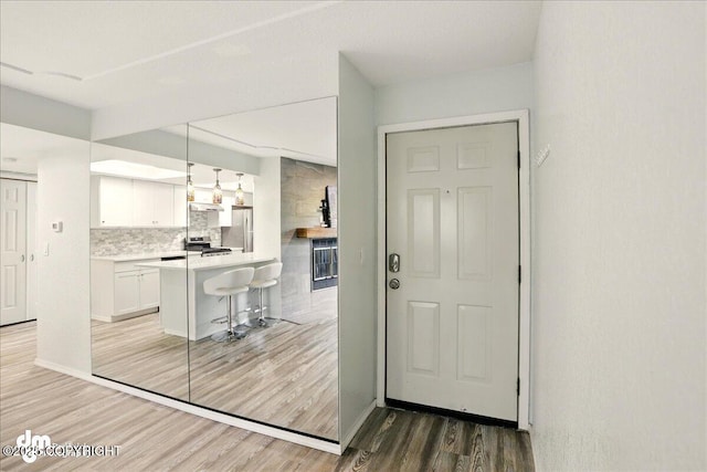 7341 Huntsmen Cir Unit 19C, Anchorage, AK 99518 - kitchen with appliances with stainless steel finishes, light wood-style flooring, a kitchen breakfast bar, white cabinets, and light countertops