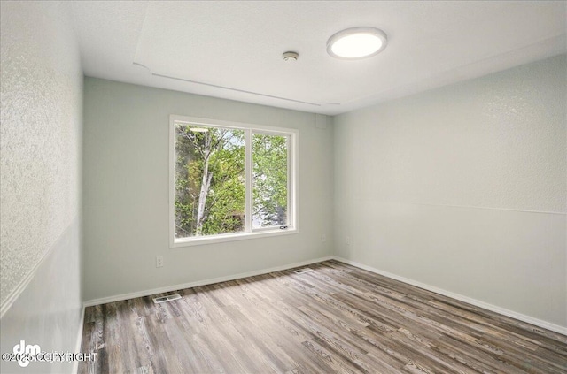 7341 Huntsmen Cir Unit 19C, Anchorage, AK 99518 - empty room featuring wood finished floors, a smoke detector, and baseboards