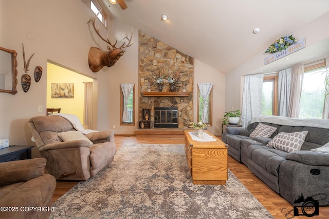 2100 N Palomino Ln, Palmer, AK 99645 - living room with high vaulted ceiling, wood finished floors, a stone fireplace, and a ceiling fan