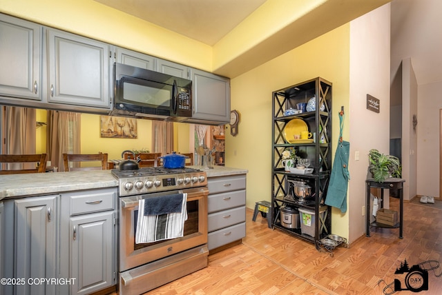 2100 N Palomino Ln, Palmer, AK 99645 - kitchen featuring stainless steel range with gas cooktop, black microwave, gray cabinetry, light wood finished floors, and light countertops