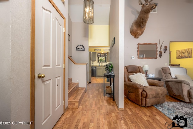 2100 N Palomino Ln, Palmer, AK 99645 - hall with stairway, light wood-style floors, a chandelier, and a high ceiling