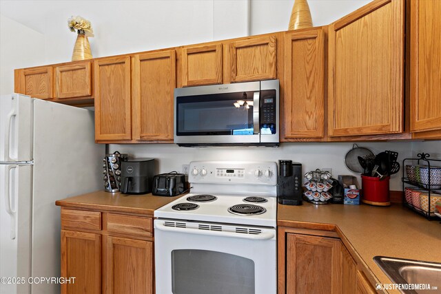 2266 Brookshire Loop, Anchorage, AK 99504 - kitchen with white appliances, light countertops, and brown cabinets
