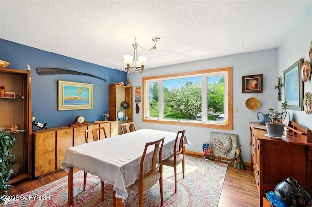 655 N Smith Rd, Palmer, AK 99645 - dining room with a chandelier, wood finished floors, a textured ceiling, and baseboards