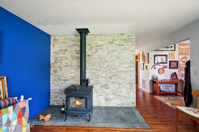 655 N Smith Rd, Palmer, AK 99645 - living room with a wood stove, wood finished floors, a textured ceiling, and radiator