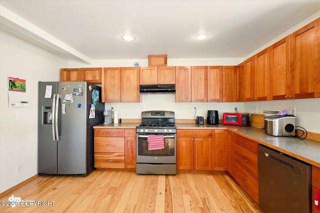 4588 Gold Mint Dr, Wasilla, AK 99654 - kitchen featuring stainless steel appliances, under cabinet range hood, light wood-type flooring, brown cabinets, and light countertops