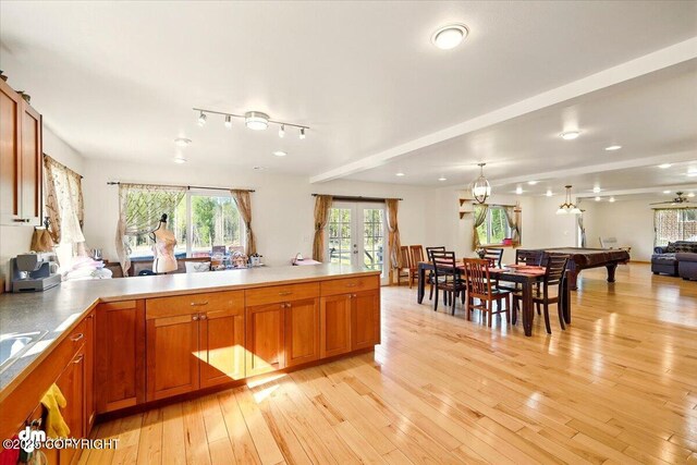 4588 Gold Mint Dr, Wasilla, AK 99654 - kitchen with light wood-type flooring, open floor plan, french doors, brown cabinets, and a peninsula