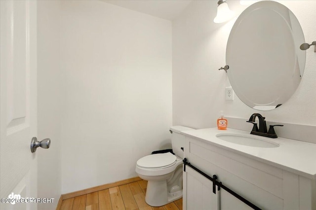 4588 Gold Mint Dr, Wasilla, AK 99654 - half bathroom featuring vanity, wood finished floors, toilet, and baseboards
