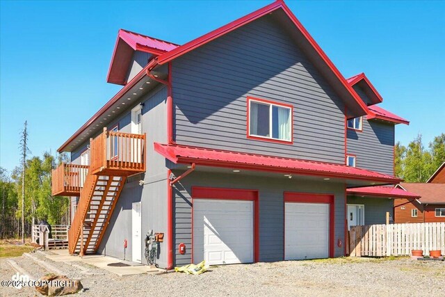 4588 Gold Mint Dr, Wasilla, AK 99654 - view of front of house featuring an attached garage, stairway, a wooden deck, and gravel driveway