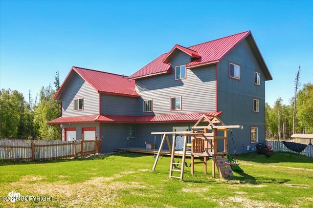 4588 Gold Mint Dr, Wasilla, AK 99654 - rear view of house with an attached garage, metal roof, and a playground