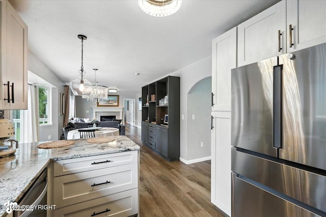 2213 N Tabasco Cat Dr, Palmer, AK 99645 - kitchen featuring stainless steel appliances, wood finished floors, light stone counters, and a fireplace