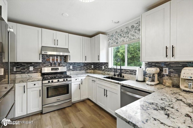 2213 N Tabasco Cat Dr, Palmer, AK 99645 - kitchen featuring stainless steel appliances, under cabinet range hood, white cabinetry, and light stone counters