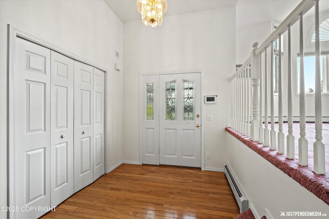 10931 Adanak Cir, Eagle River, AK 99577 - foyer entrance with a baseboard heating unit, hardwood / wood-style flooring, a towering ceiling, baseboards, and baseboard heating