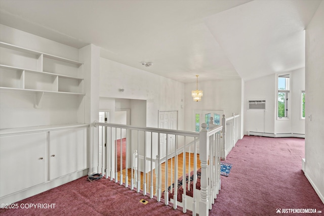 10931 Adanak Cir, Eagle River, AK 99577 - hallway featuring carpet floors, an upstairs landing, a chandelier, an AC wall unit, and baseboard heating