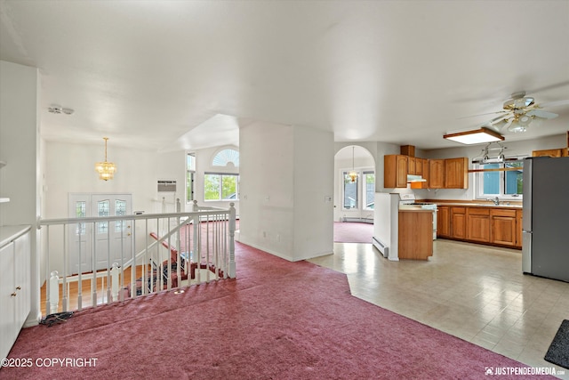 10931 Adanak Cir, Eagle River, AK 99577 - kitchen featuring freestanding refrigerator, white gas stove, open floor plan, under cabinet range hood, and brown cabinets