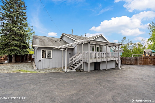 10931 Adanak Cir, Eagle River, AK 99577 - back of property featuring stairway, a wooden deck, roof with shingles, and a patio area