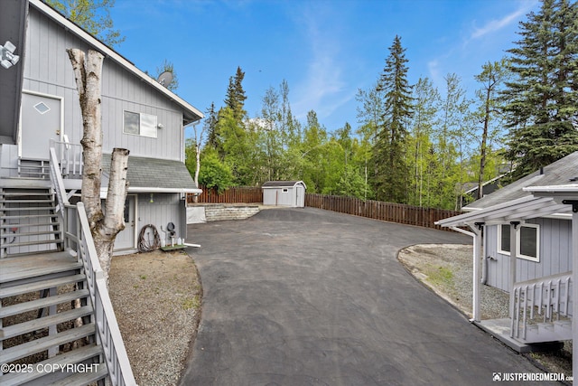 10931 Adanak Cir, Eagle River, AK 99577 - view of side of property with stairs, a fenced backyard, a patio, and driveway