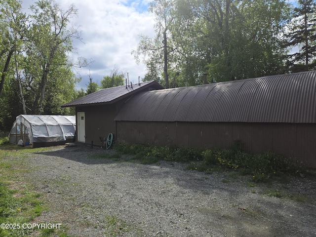 17690 E Idle Dr, Palmer, AK 99645 - view of side of home with metal roof, an outbuilding, and a greenhouse