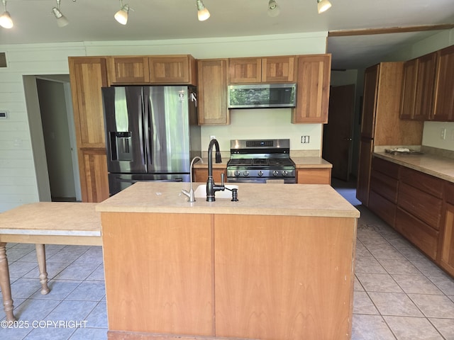 17690 E Idle Dr, Palmer, AK 99645 - kitchen with stainless steel appliances, a sink, light tile patterned floors, and brown cabinets