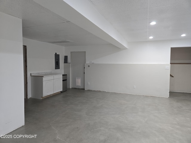 17690 E Idle Dr, Palmer, AK 99645 - unfurnished living room featuring electric panel, concrete flooring, recessed lighting, and a drop ceiling