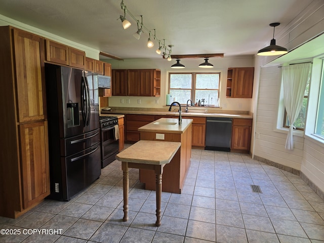 17690 E Idle Dr, Palmer, AK 99645 - kitchen featuring stainless steel appliances, open shelves, light countertops, a kitchen island with sink, and brown cabinetry