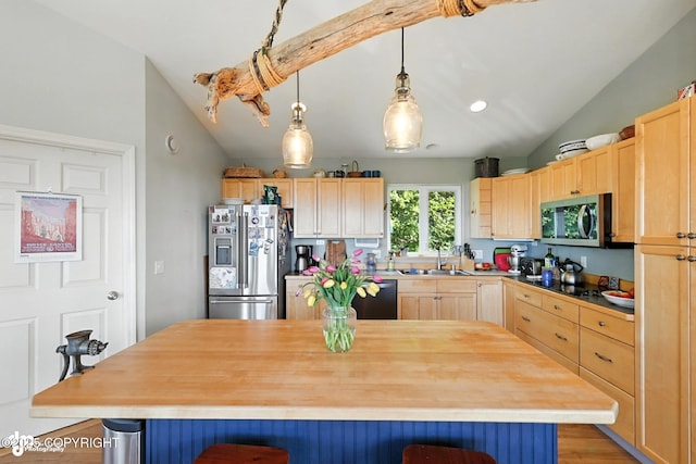 41722 Charlie Dr, Homer, AK 99603 - kitchen with appliances with stainless steel finishes, vaulted ceiling, light brown cabinetry, a breakfast bar area, and wooden counters