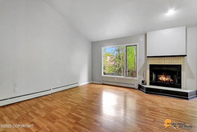 18739 Sarichef Loop, Eagle River, AK 99577 - unfurnished living room with a baseboard heating unit, wood finished floors, a tile fireplace, vaulted ceiling, and baseboards