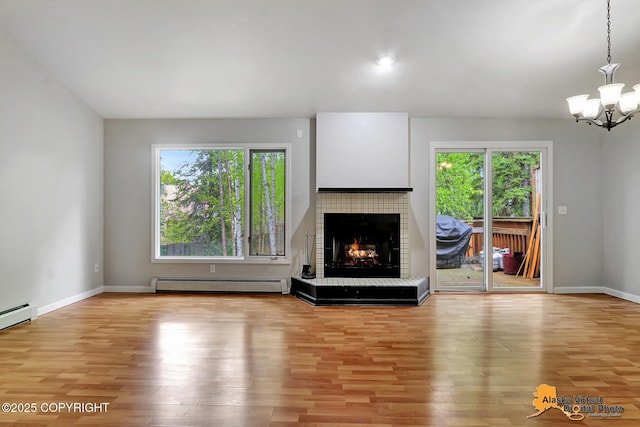 18739 Sarichef Loop, Eagle River, AK 99577 - unfurnished living room with a baseboard heating unit, wood finished floors, a lit fireplace, and a chandelier