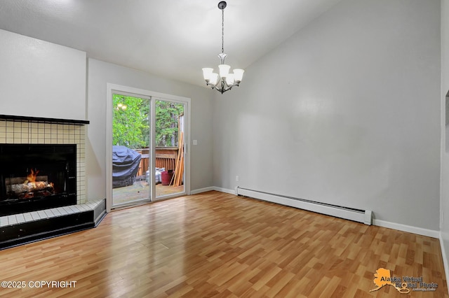 18739 Sarichef Loop, Eagle River, AK 99577 - unfurnished living room featuring a baseboard heating unit, wood finished floors, a chandelier, lofted ceiling, and a tiled fireplace