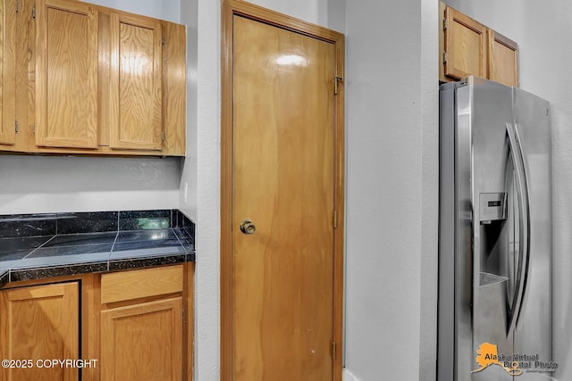 18739 Sarichef Loop, Eagle River, AK 99577 - kitchen with stainless steel fridge, tile counters, and a textured wall