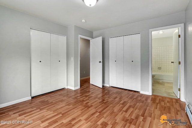 18739 Sarichef Loop, Eagle River, AK 99577 - unfurnished bedroom with baseboard heating, two closets, light wood finished floors, and ensuite bath