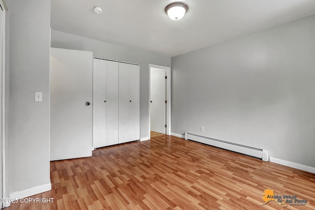18739 Sarichef Loop, Eagle River, AK 99577 - unfurnished bedroom with a baseboard heating unit, light wood finished floors, baseboards, and a closet