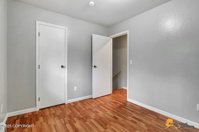 18739 Sarichef Loop, Eagle River, AK 99577 - unfurnished bedroom with light wood-style flooring and baseboards