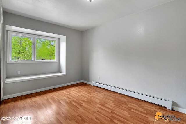 18739 Sarichef Loop, Eagle River, AK 99577 - empty room featuring a baseboard heating unit, light wood-style flooring, and baseboards