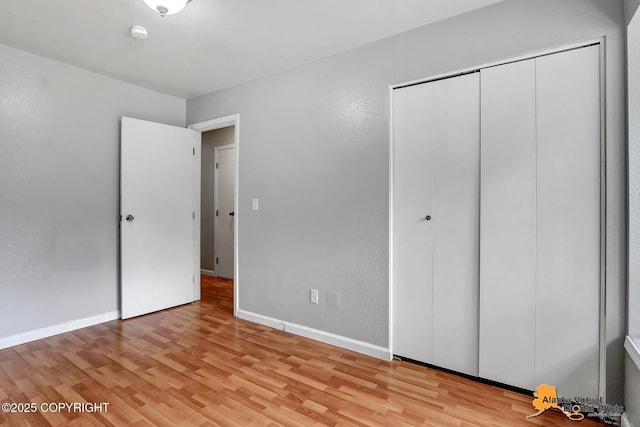 18739 Sarichef Loop, Eagle River, AK 99577 - unfurnished bedroom featuring light wood-style flooring, a closet, and baseboards