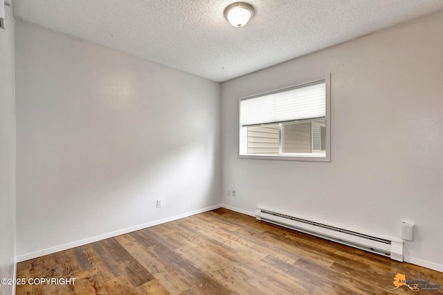 7075 Weimer Rd # 6, Anchorage, AK 99502 - unfurnished room with a baseboard radiator, wood finished floors, a textured ceiling, and baseboards