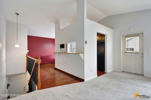 7075 Weimer Rd # 6, Anchorage, AK 99502 - kitchen featuring carpet, vaulted ceiling, decorative light fixtures, baseboards, and freestanding refrigerator