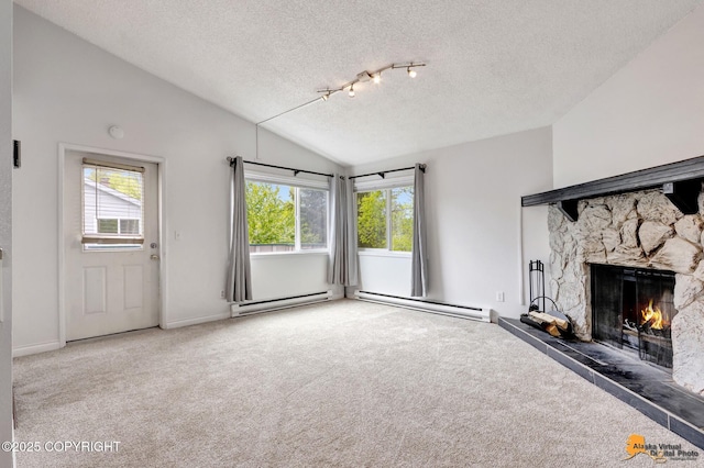 7075 Weimer Rd # 6, Anchorage, AK 99502 - unfurnished living room featuring a textured ceiling, carpet floors, plenty of natural light, a stone fireplace, and vaulted ceiling