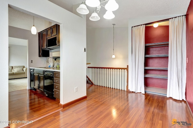 7075 Weimer Rd # 6, Anchorage, AK 99502 - kitchen featuring a sink, dishwasher, light countertops, wood finished floors, and a chandelier