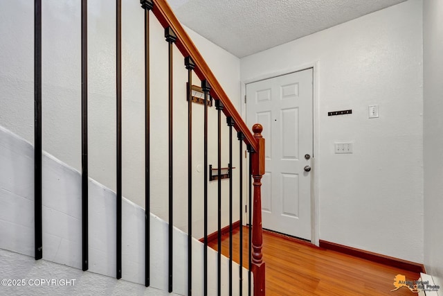 7075 Weimer Rd # 6, Anchorage, AK 99502 - entryway featuring stairway, a textured ceiling, wood finished floors, and baseboards