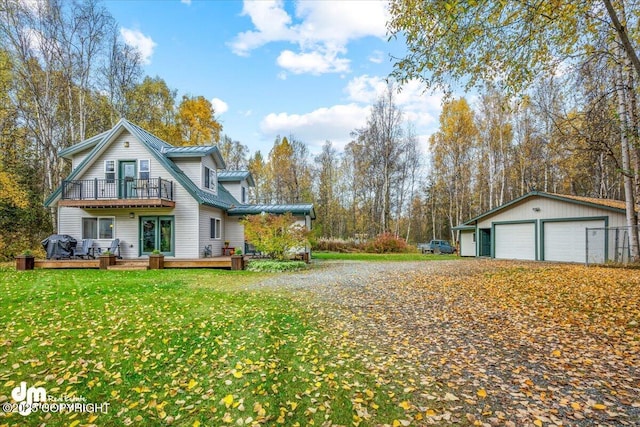 20838 Helluva St, Chugiak, AK 99567 - view of property exterior featuring a balcony, a garage, a wooden deck, metal roof, and a lawn