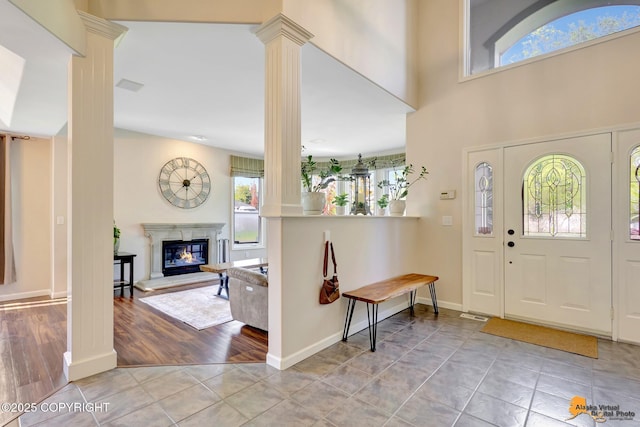 740 Botanical Heights Cir, Anchorage, AK 99515 - entrance foyer featuring ornate columns, a premium fireplace, tile patterned flooring, and baseboards