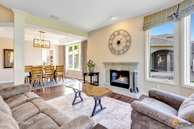 740 Botanical Heights Cir, Anchorage, AK 99515 - living room featuring wood finished floors, a glass covered fireplace, baseboards, and a chandelier