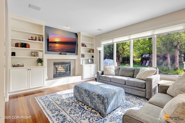 740 Botanical Heights Cir, Anchorage, AK 99515 - living room featuring wood finished floors, a glass covered fireplace, and built in shelves