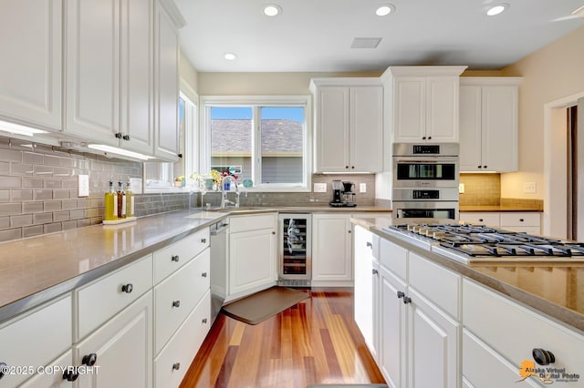 740 Botanical Heights Cir, Anchorage, AK 99515 - kitchen featuring beverage cooler, stainless steel appliances, light wood finished floors, white cabinets, and tasteful backsplash