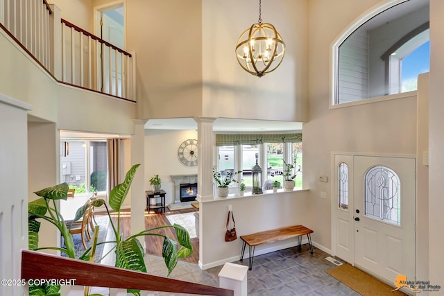 740 Botanical Heights Cir, Anchorage, AK 99515 - foyer entrance with healthy amount of natural light, a high ceiling, a chandelier, a premium fireplace, and baseboards