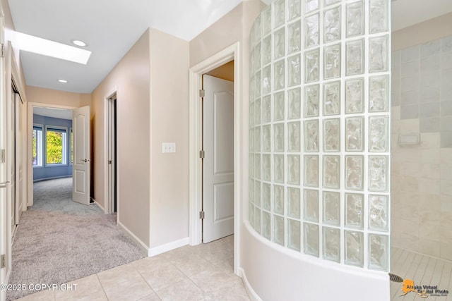 740 Botanical Heights Cir, Anchorage, AK 99515 - hallway with light tile patterned floors, light carpet, baseboards, and a skylight
