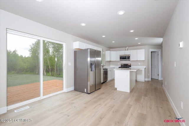 9089 E Spring Creek Cir, Palmer, AK 99645 - kitchen featuring appliances with stainless steel finishes, light countertops, light wood-style floors, white cabinets, and baseboards