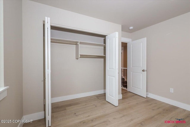 9089 E Spring Creek Cir, Palmer, AK 99645 - unfurnished bedroom with wood finished floors, a closet, and baseboards